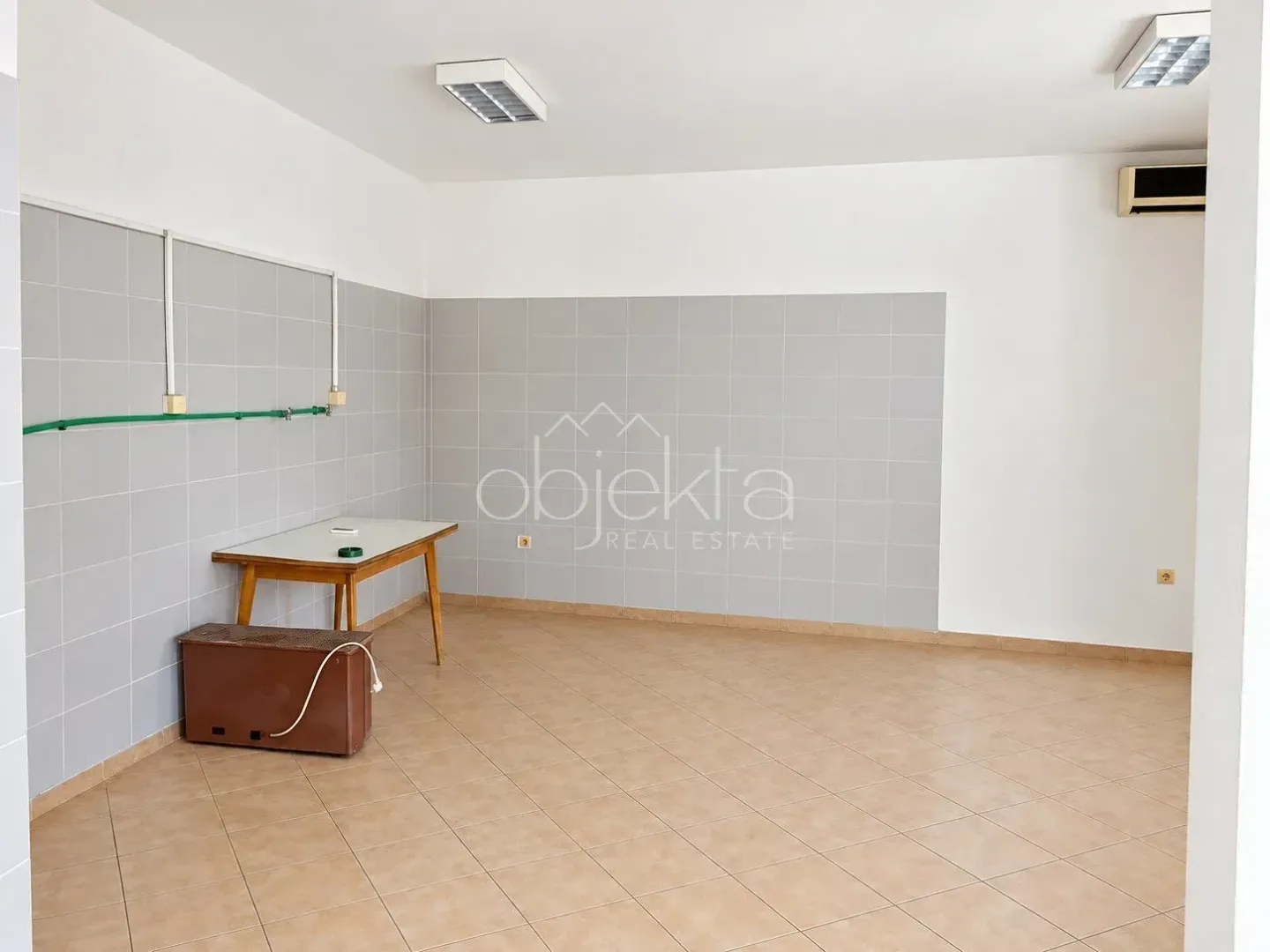 Empty room with tiles on the lower part of the walls and installations.