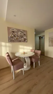 Trpezarijski sto sa roze stolicama i slikom na zidu u dnevnom boravku. - image 14