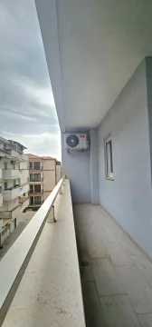Spacious tiled balcony overlooking neighboring buildings. - image 7
