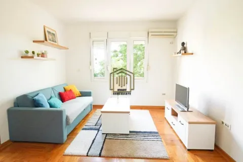 Living room with a sofa, TV unit, and wall shelves. - image 2