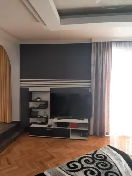 Living room with a television and a dark accent wall with white details. - image 23