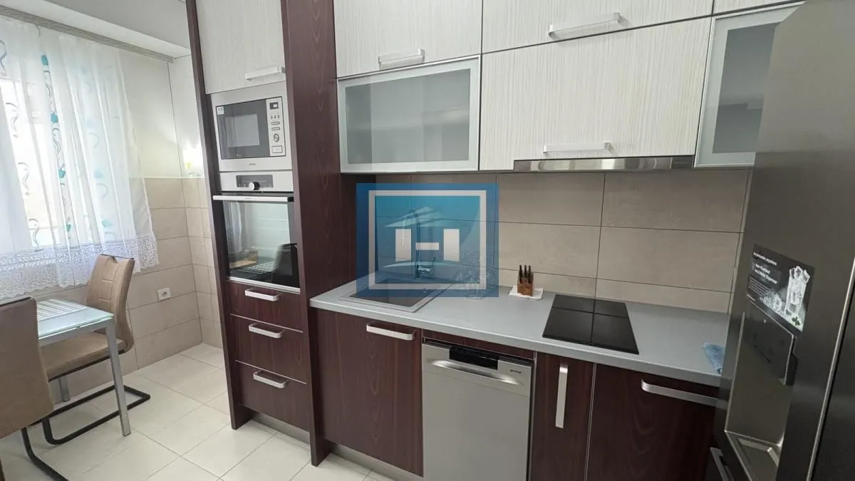Equipped kitchen with wooden cabinets and built-in appliances.