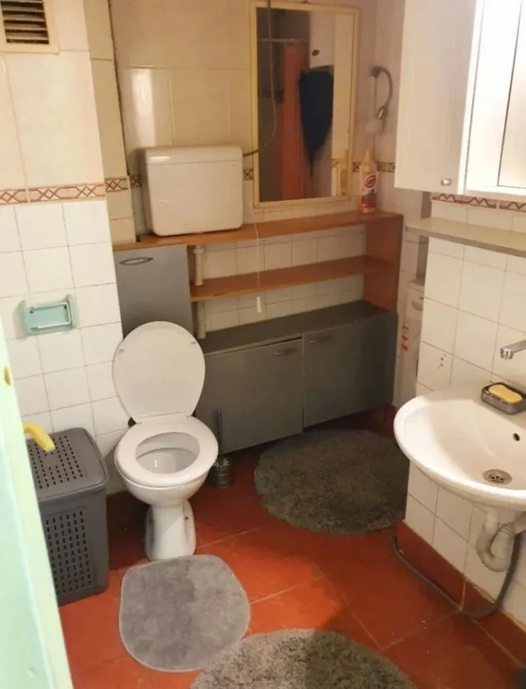 Kupatilo sa toaletom, lavaboom i ogledalom.