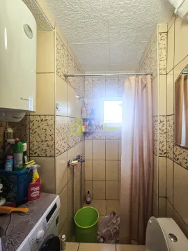 Manje kupatilo obloženo keramičkim pločicama sa tuš kabinom i veš mašinom. - image 3