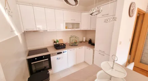 Modern white kitchen with built-in appliances and a dining area. - image 8