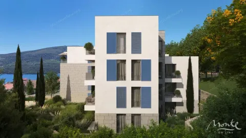 Pogled na spoljašnjost moderne stambene zgrade okružene zelenilom i pogledom na more. - image 6