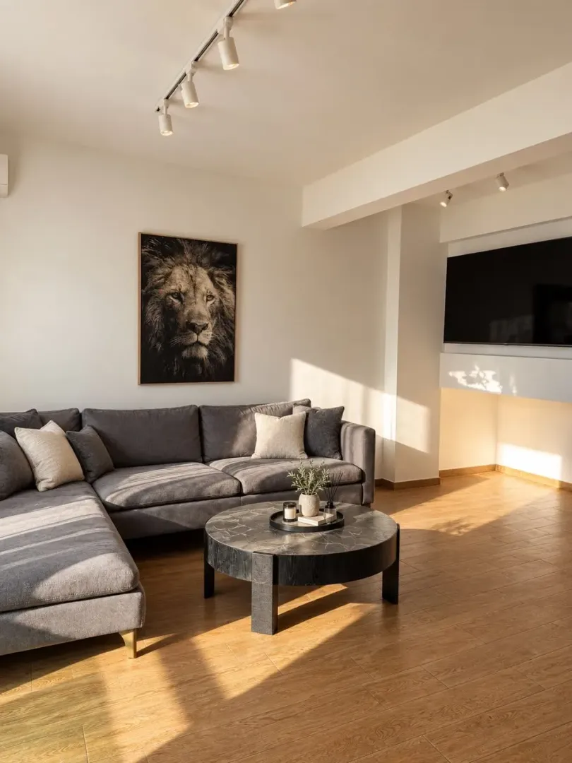 Living room with a sectional sofa, coffee table, and a lion painting on the wall.
