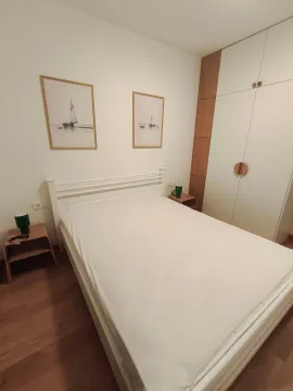 Uređena spavaća soba sa bračnim krevetom, plakarom i noćnim stočićima. - image 3