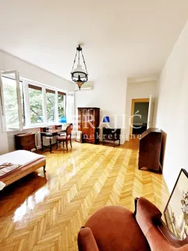 Spacious living room with wooden parquet flooring and vintage furniture. - image 11