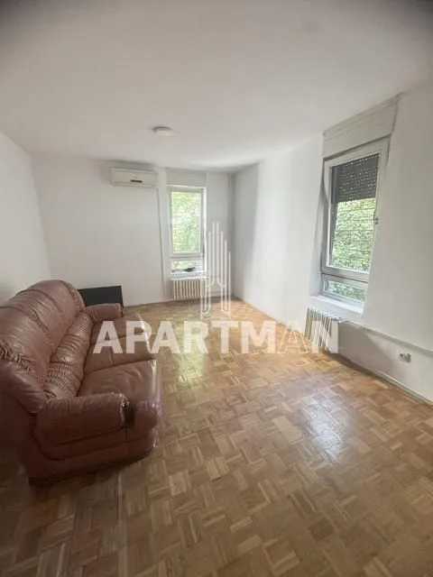 Living room with a leather armchair and wooden parquet flooring.