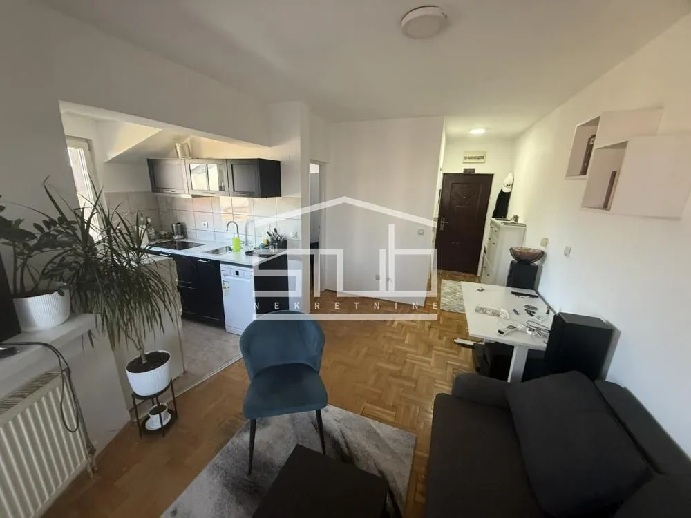 Living room connected to the kitchen in an apartment with parquet flooring.