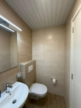Manje kupatilo sa lavaboom, wc šoljom i ogledalom. - image 6