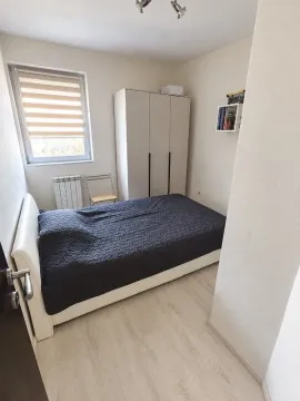 Manja spavaća soba sa bračnim krevetom, ormarom i prozorom. - image 8