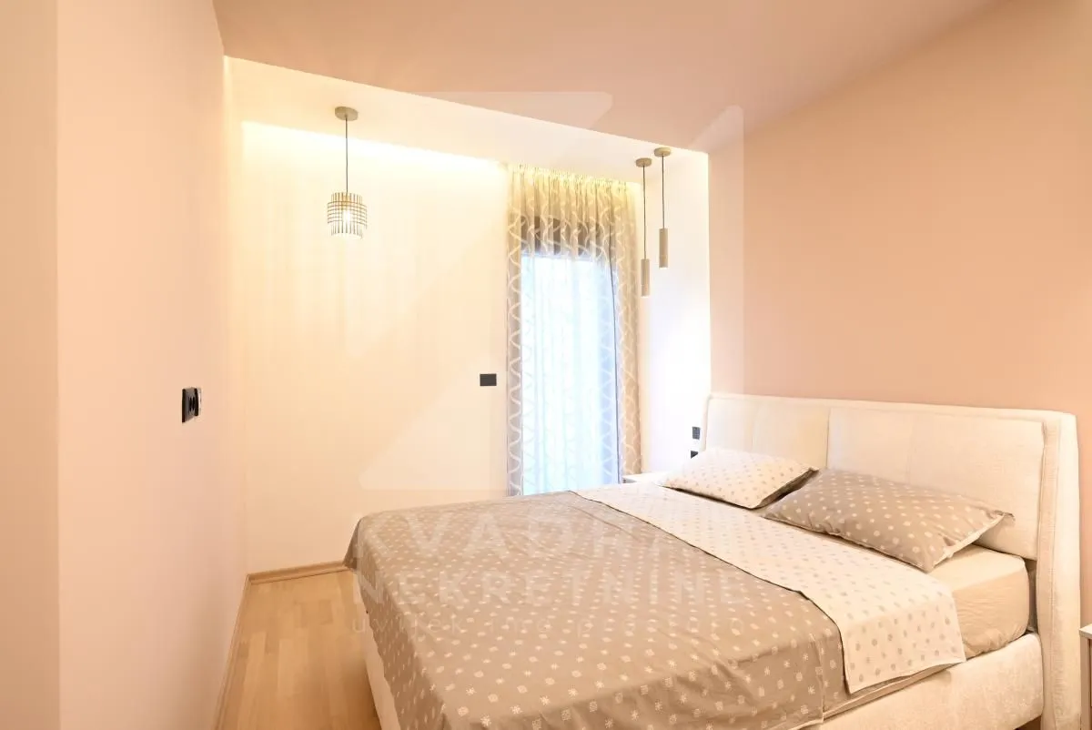 Bedroom with a double bed and a window with curtains.