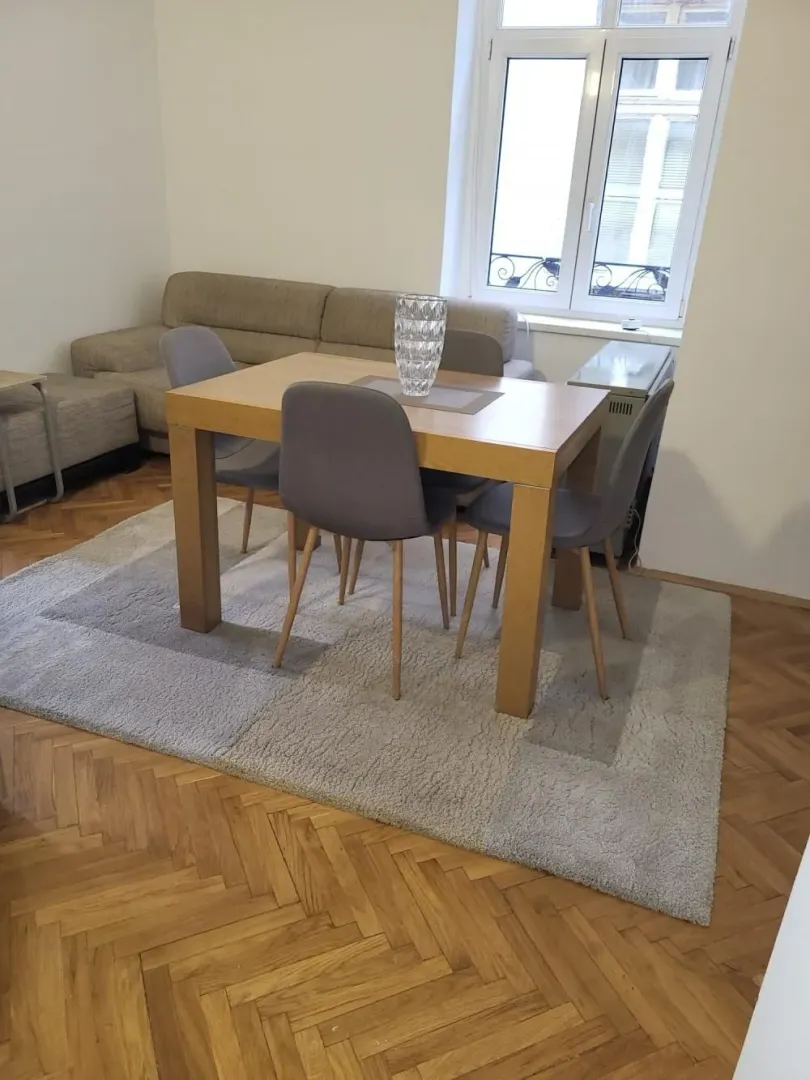 Dnevna soba sa trpezarijskim stolom, stolicama i ugaonom garniturom.