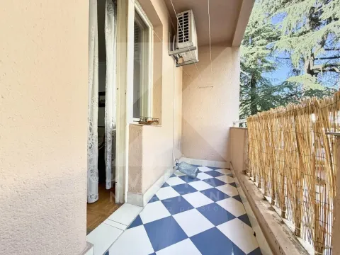 Covered balcony with blue and white tiled flooring and a wooden fence. - image 3