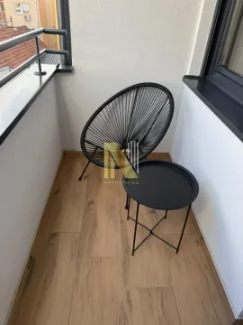 Small furnished balcony with a chair and a small table. - image 5
