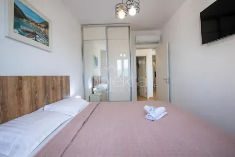 Furnished bedroom with a double bed, wardrobe, and television. - image 10