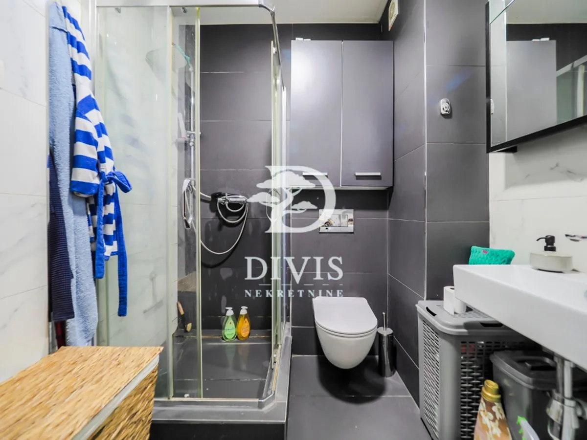 Moderno opremljeno kupatilo sa tuš kabinom, wc šoljom i umivaonikom.