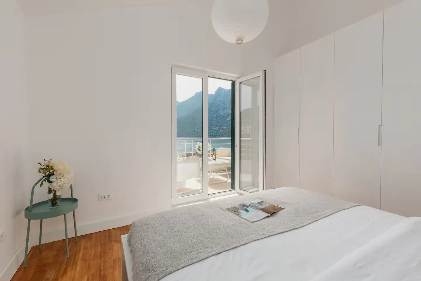 Bright bedroom with a double bed, fitted wardrobe, and access to a terrace with a sea view.