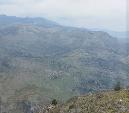 Panoramski pogled na planinski predio pod oblačnim nebom. - image 2