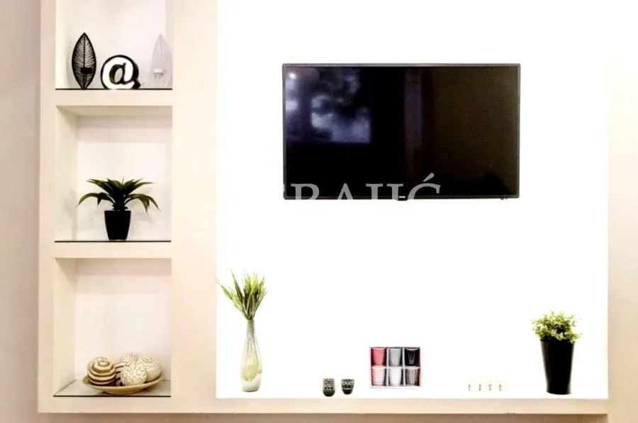 Living room with built-in shelves and a wall-mounted TV.