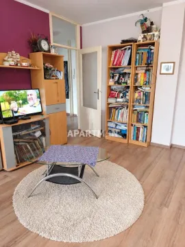 Dnevna soba sa drvenim nameštajem, policama za knjige i televizorom. - image 4