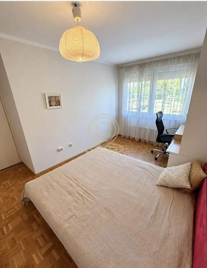 Furnished bedroom with a double bed, desk, and a window overlooking the yard.