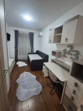 Children's room furnished with a bed, desk, and wall units. - image 8