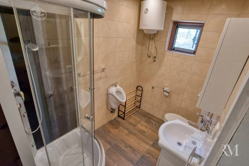 Compact bathroom with a shower cabin, washbasin, and toilet.