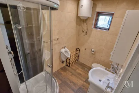 Compact bathroom with a shower cabin, washbasin, and toilet. - image 5