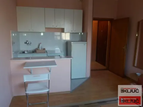 Smaller kitchen with white cabinets and a breakfast bar. - image 3