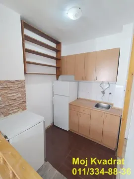 Manja kuhinja sa drvenim elementima, frižiderom i sudoperom. - image 3
