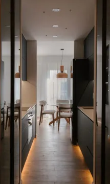 Modern kitchen with dark cabinets and a dining area in the background. - image 2