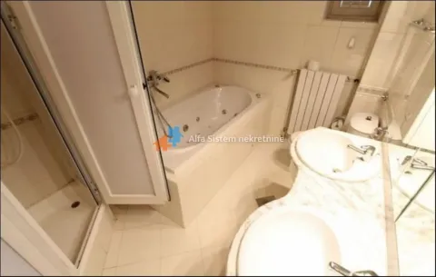 Bathroom equipped with a bathtub, shower cabin, and double vanity. - image 19