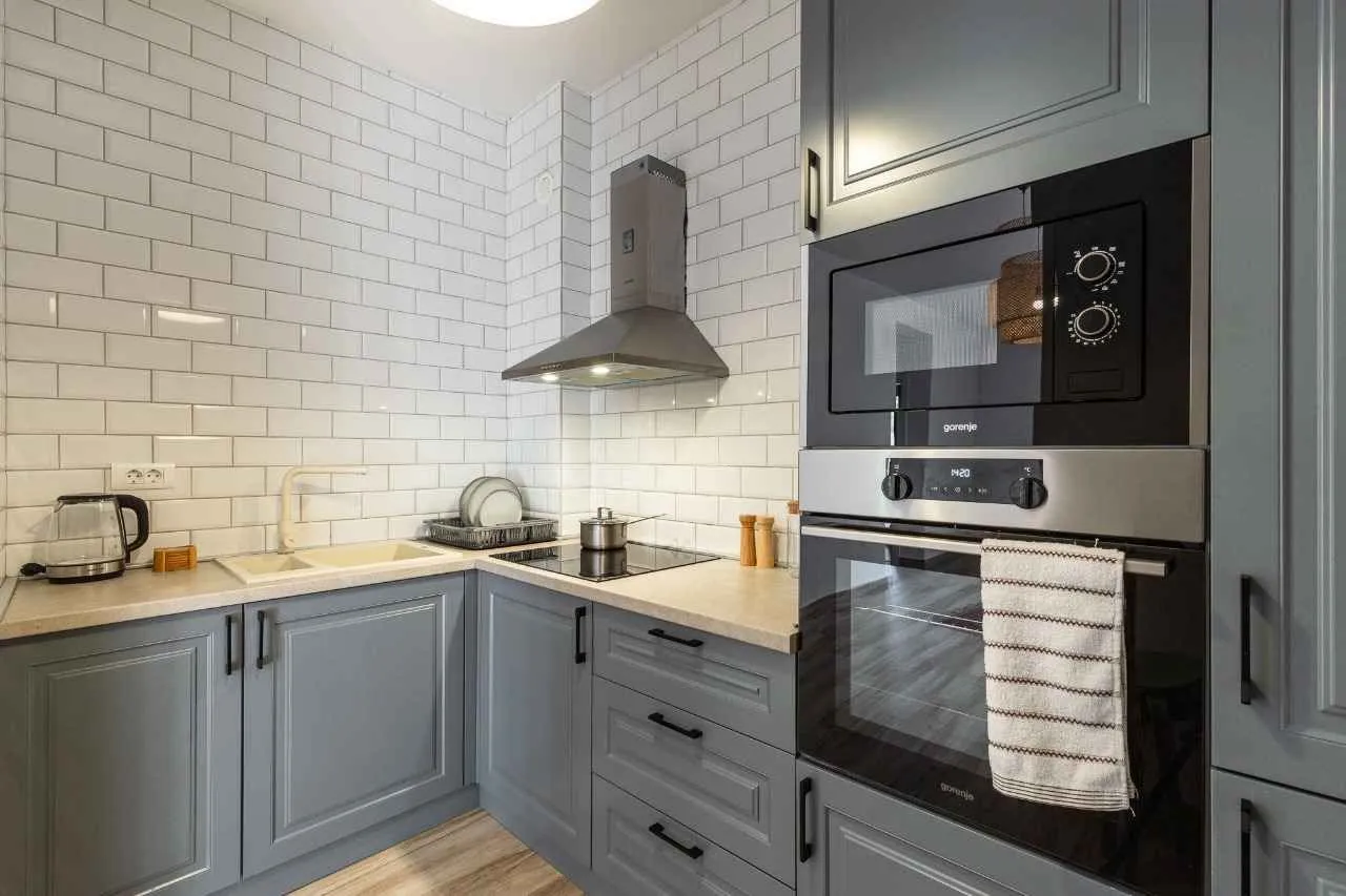Modern kitchen with grey cabinets and built-in appliances.