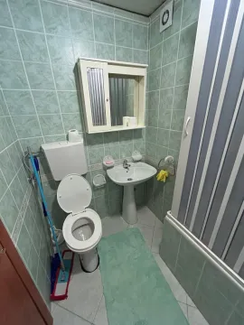 Manje kupatilo sa zelenim pločicama, umivaonikom, WC šoljom i tuš kabinom. - image 18