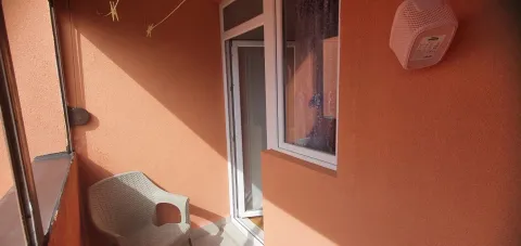 Mali balkon sa plastičnom stolicom i narandžastim zidovima. - image 9