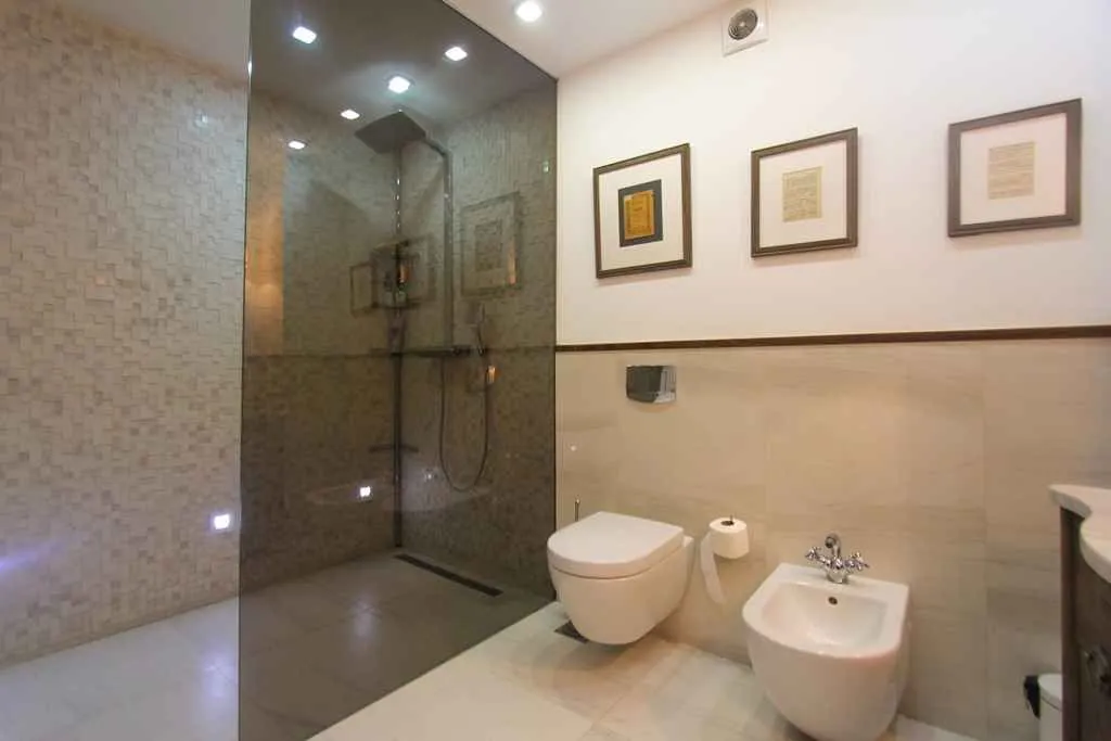 Moderne kupatilo sa tuš kabinom, wc šoljom i bideom.