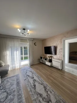 Bright living room with an accent wall and television. - image 11
