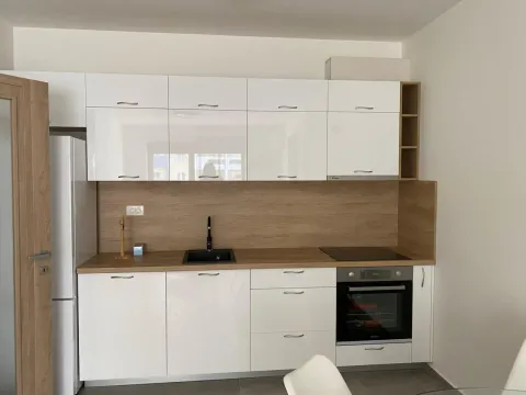 Modern kitchen with high-gloss white cabinets and a wood-grain countertop. - image 5