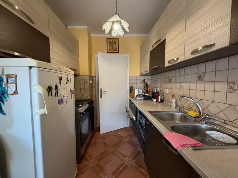 Smaller kitchen with wood-patterned cabinets and white appliances. - image 3
