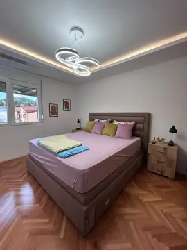Modern bedroom with a double bed, parquet flooring, and decorative lighting. - image 8