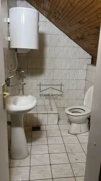 Small bathroom with a sink, toilet, and water heater under a sloped ceiling. - image 5