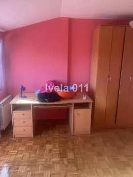 Manja spavaća soba sa roze zidom, drvenim radnim stolom i ormarom. - image 4