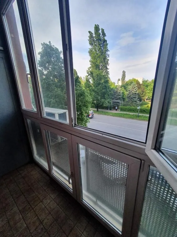 Pogled sa zatvorene terase na ulicu i zelenilo.
