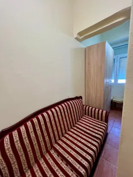 Living room with a sofa and a passageway to a room with a wardrobe. - image 8