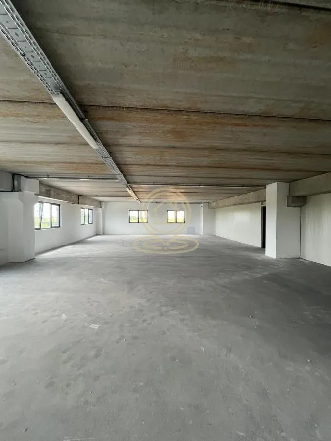 Large unfinished space in bare shell condition with a concrete ceiling and columns.