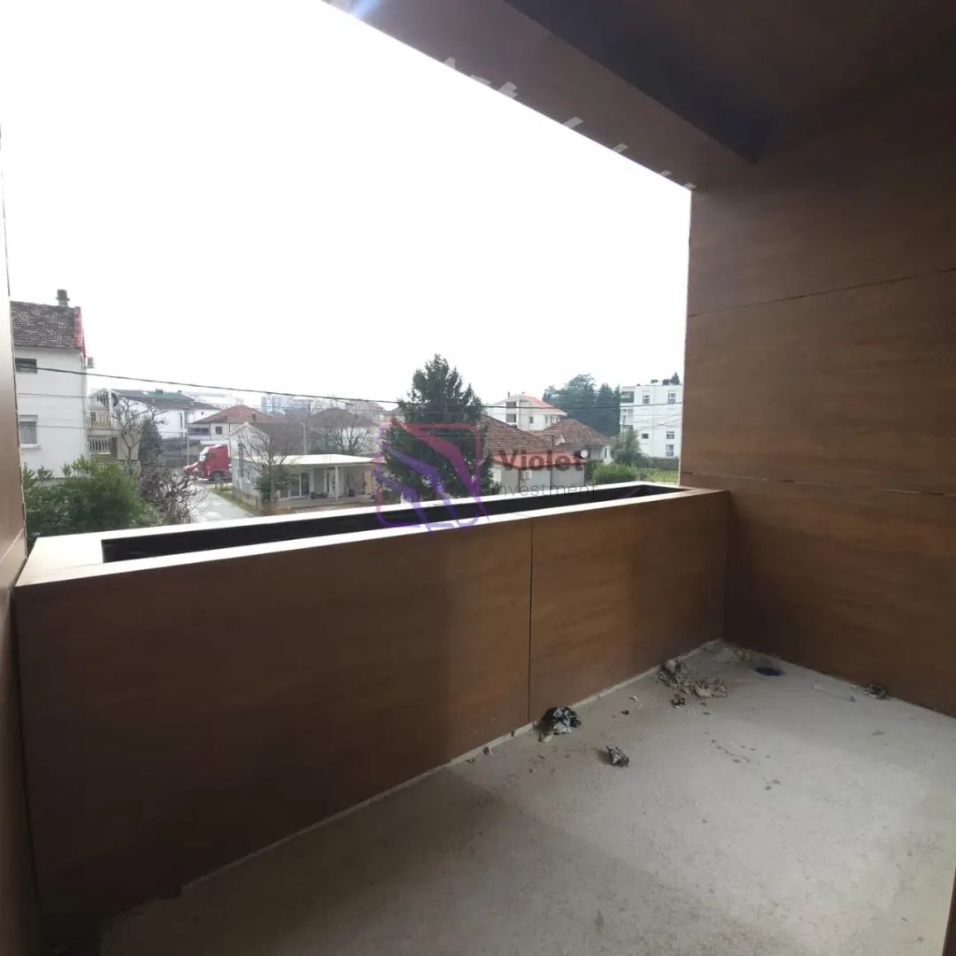 Pogled sa popločane terase na okolne zgrade i naselje.