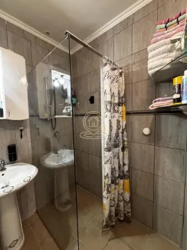 Kupatilo obloženo keramičkim pločicama sa tuš kabinom i umivaonikom. - image 2